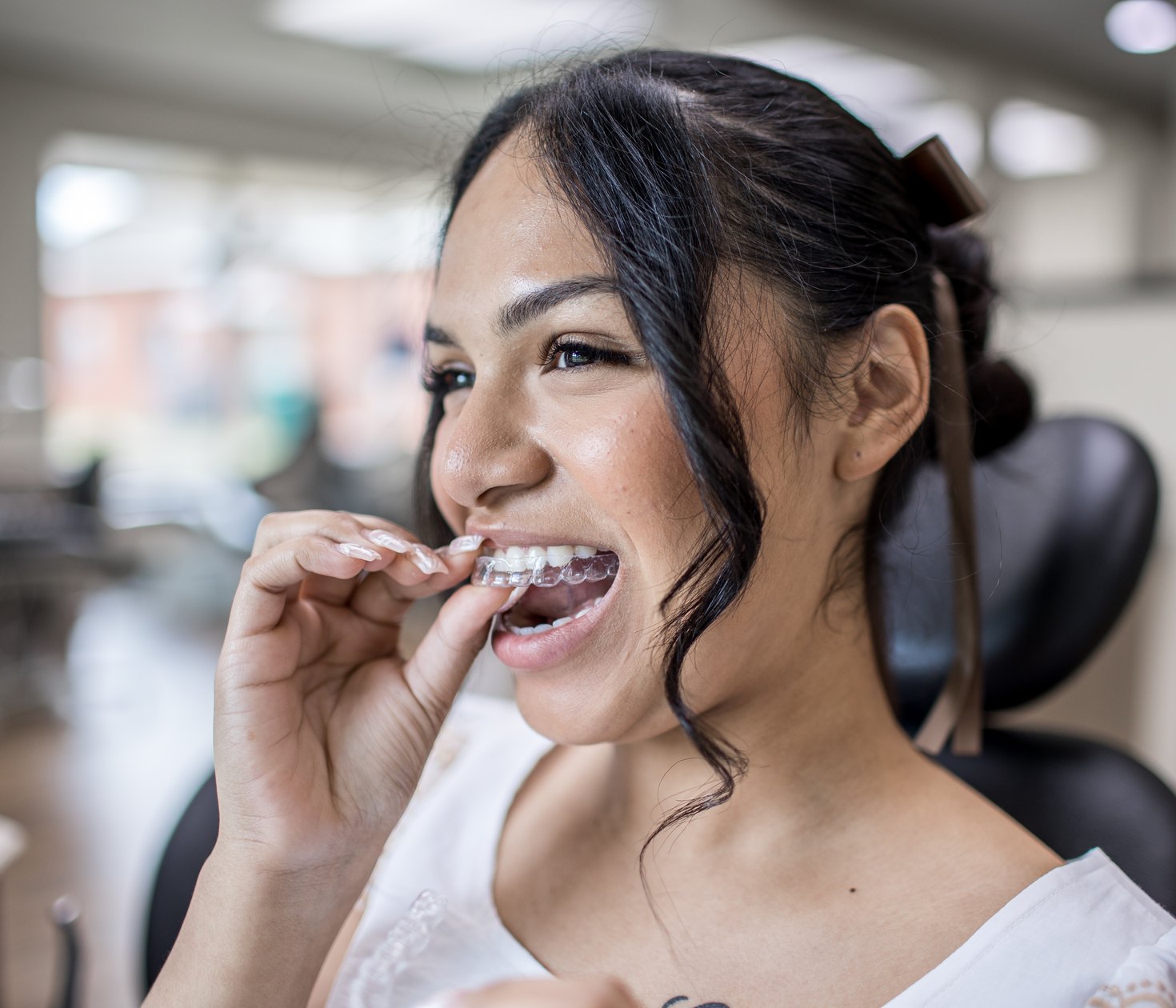 A patient placing a clear aligner tray.